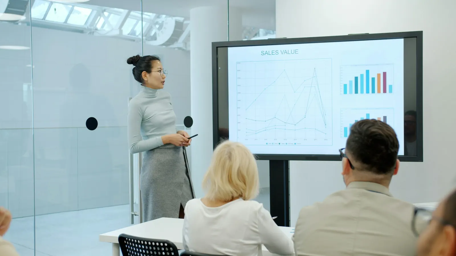 A marketer presenting results on a screen to clients